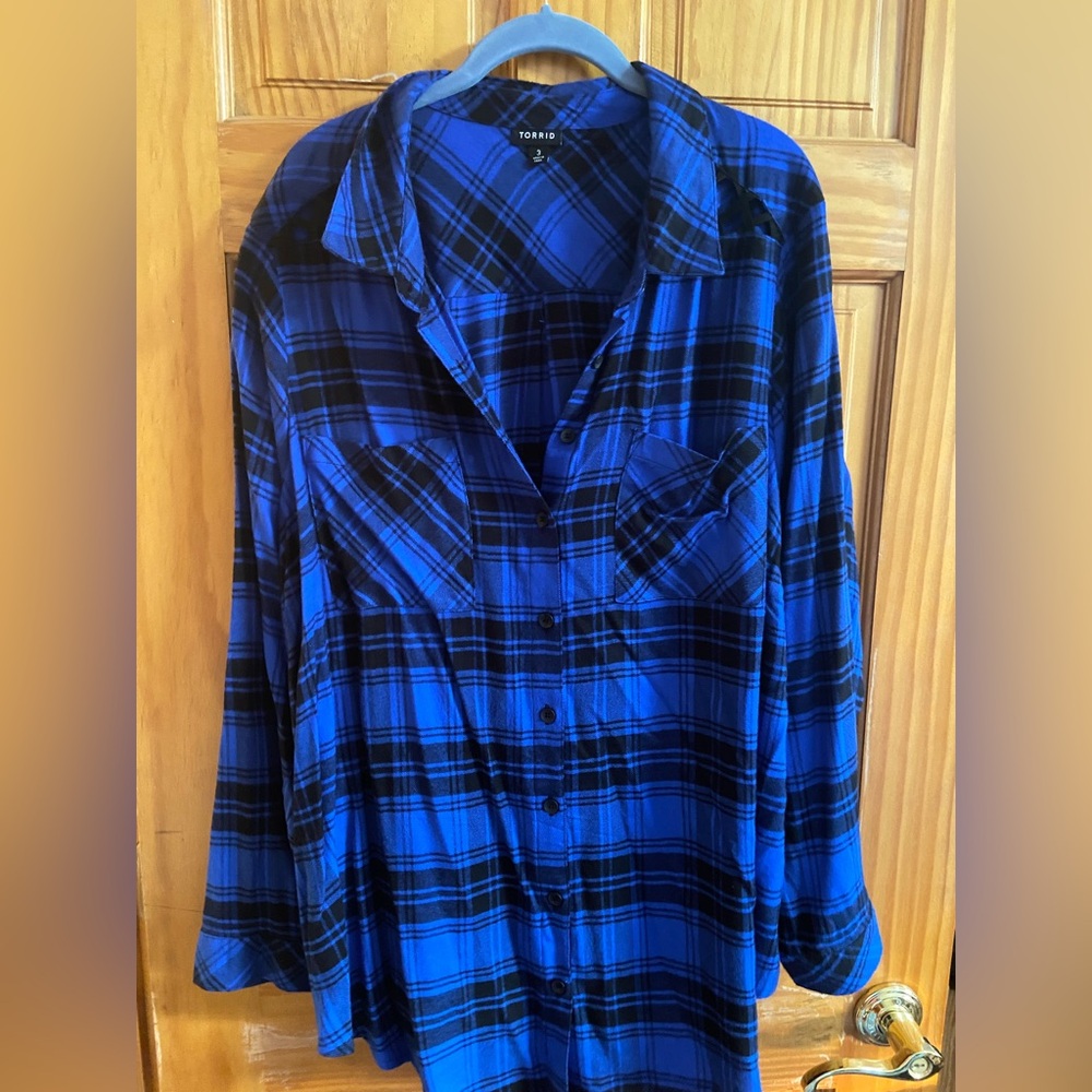 Long sleeve black and blue plaid shirt. Cut out on shoulders.